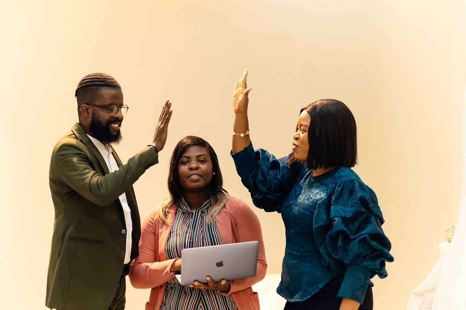Three colleagues in a Lagos office, two of them shaking hands